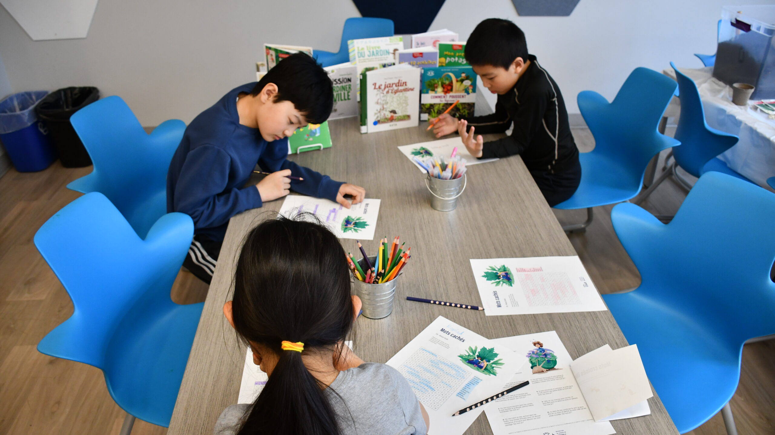 Des enfants autour d'une table font une activité de mots croisés .